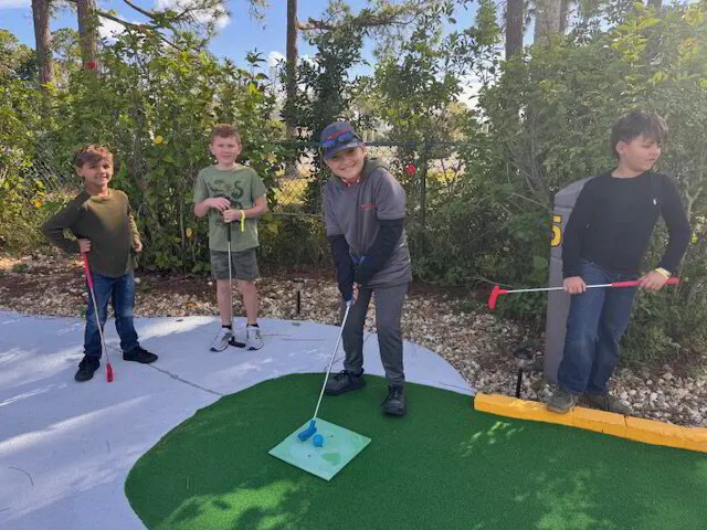 Kids playing mini-golf outdoors