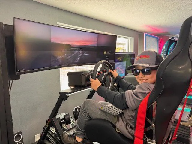 A child playing a racing game on a simulator